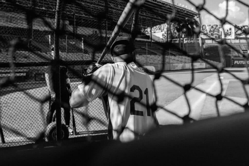 Baseball player waiting near the dugout before taking the field, highlighting the mentorship, encouragement, and lessons often shared through dugout conversations.