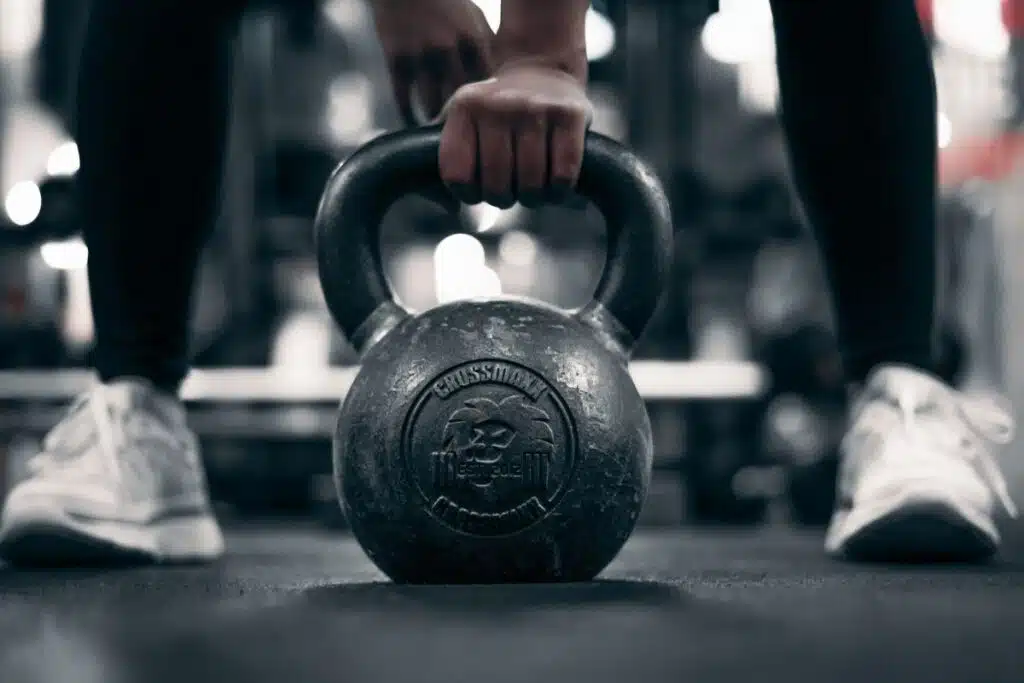 Athlete lifting a kettlebell during a year-round strength and fitness workout